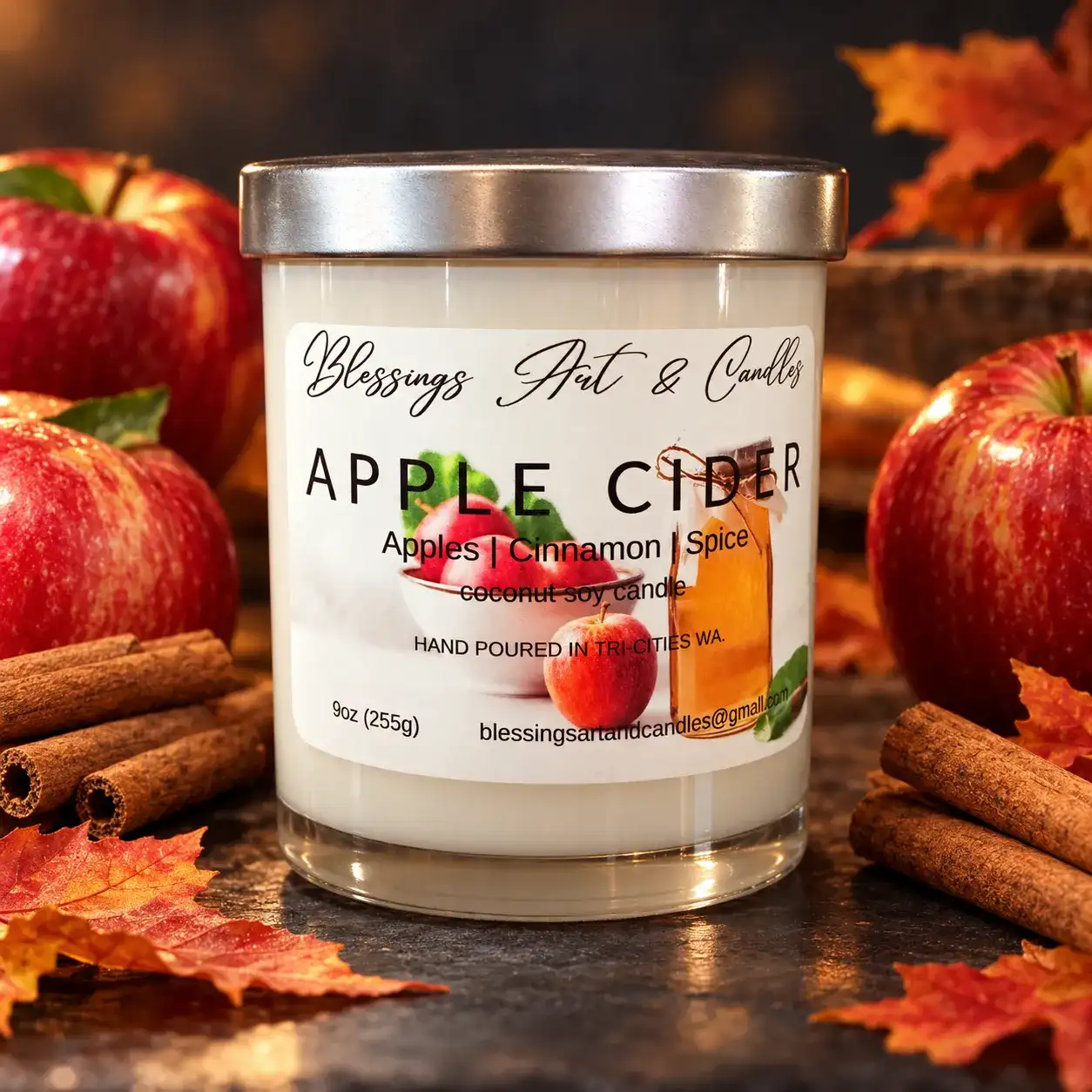 Apple Cider candle in a glass jar with red apples, cinnamon sticks and fall leaves