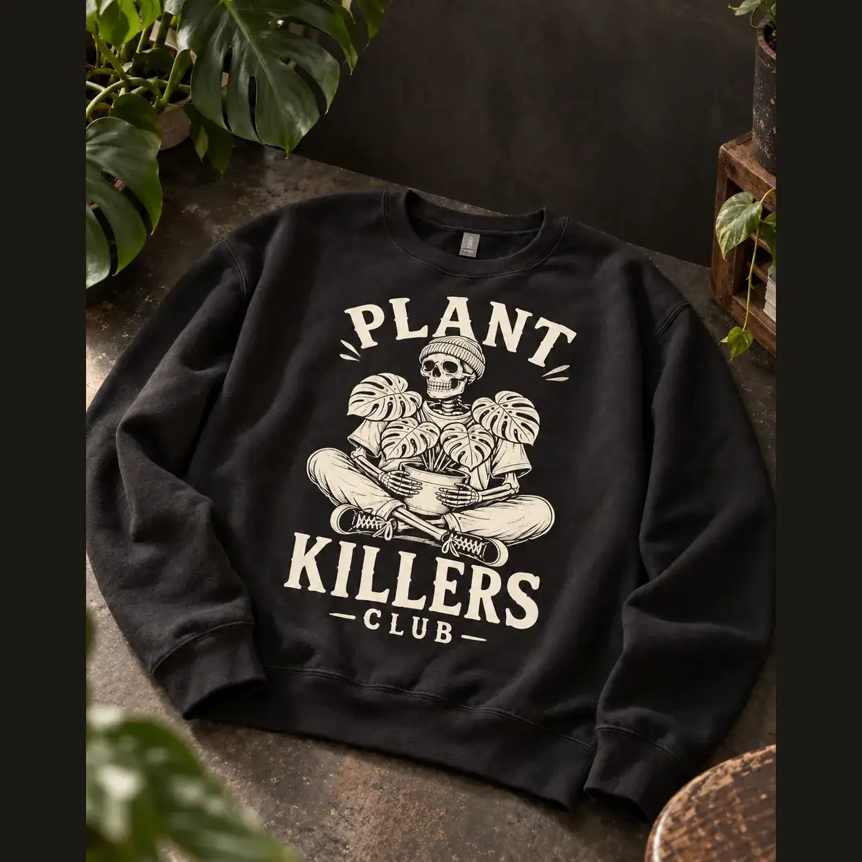 Black Plant Killers Club crewneck with a cream skeleton holding a monstera