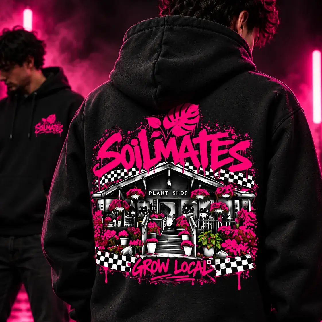 Back of the black SOILMATES Street Hoodie, worn: SOILMATES in hot pink graffiti over a drawing of our storefront, with checkered banners and Grow Local